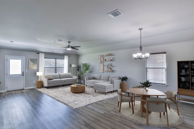 living room with hardwood / wood-style floors and ceiling fan with notable chandelier