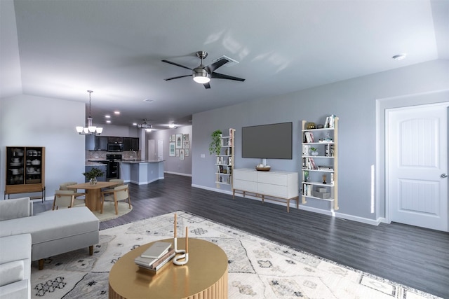 living room with dark wood-type flooring, ceiling fan with notable chandelier, and vaulted ceiling