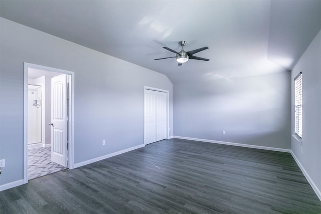 unfurnished bedroom featuring a closet, ceiling fan, vaulted ceiling, and dark hardwood / wood-style flooring