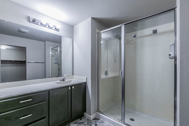 bathroom featuring vanity, a textured ceiling, and walk in shower