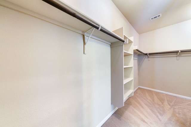 walk in closet featuring light carpet