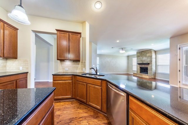 kitchen with dark hardwood / wood-style floors, decorative light fixtures, dishwasher, sink, and backsplash