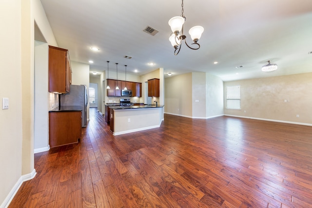 kitchen featuring sink, a chandelier, hanging light fixtures, dark hardwood / wood-style floors, and stainless steel appliances