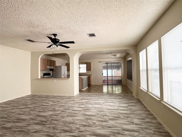 unfurnished living room featuring a textured ceiling and ceiling fan