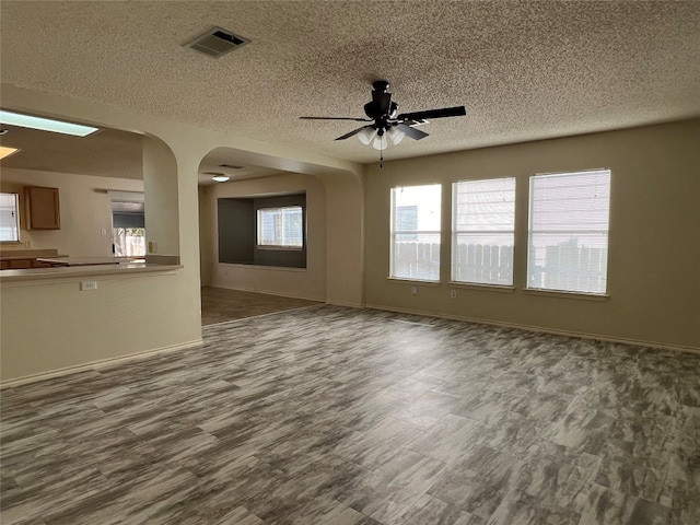 unfurnished living room with hardwood / wood-style floors, a textured ceiling, and ceiling fan