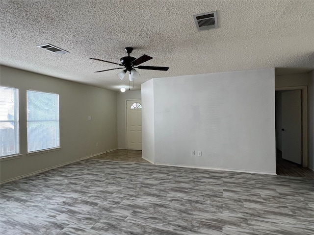 empty room featuring a textured ceiling and ceiling fan