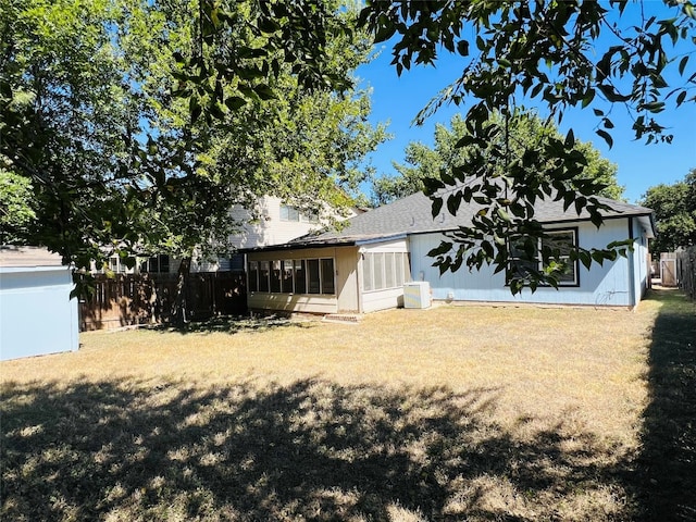 back of house featuring a yard, central AC unit, and a sunroom