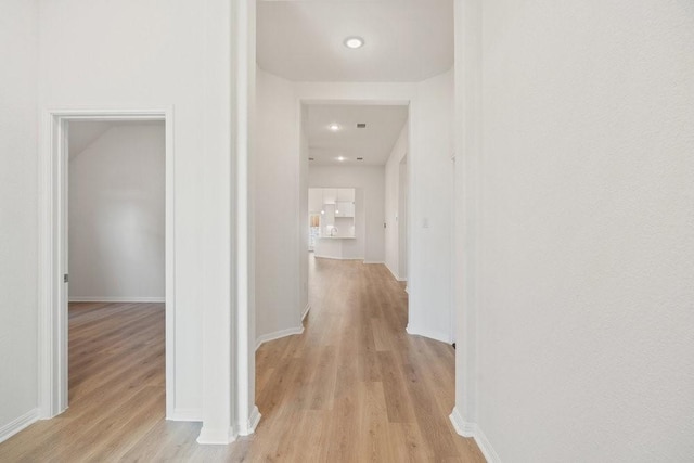 hallway with light hardwood / wood-style floors