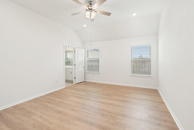 unfurnished bedroom with lofted ceiling, light wood-type flooring, connected bathroom, and ceiling fan