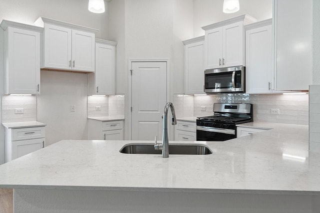 kitchen featuring white cabinetry, sink, decorative backsplash, and stainless steel appliances