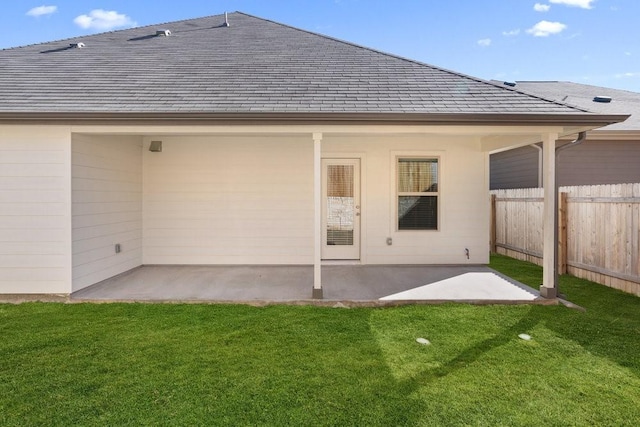 back of property with a patio area and a lawn