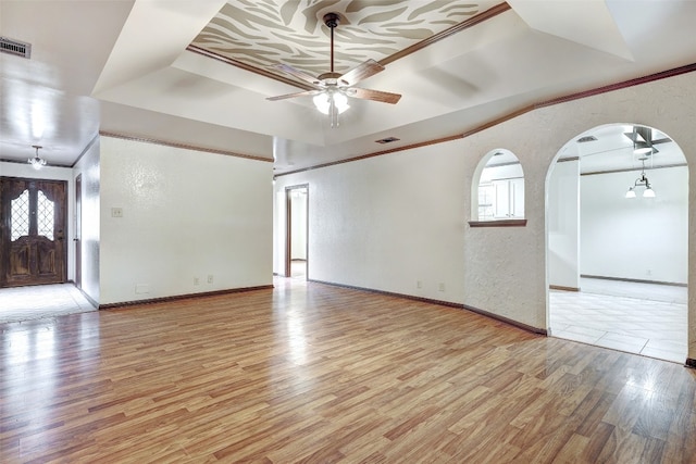 unfurnished living room featuring light hardwood / wood-style floors, crown molding, a wealth of natural light, and ceiling fan