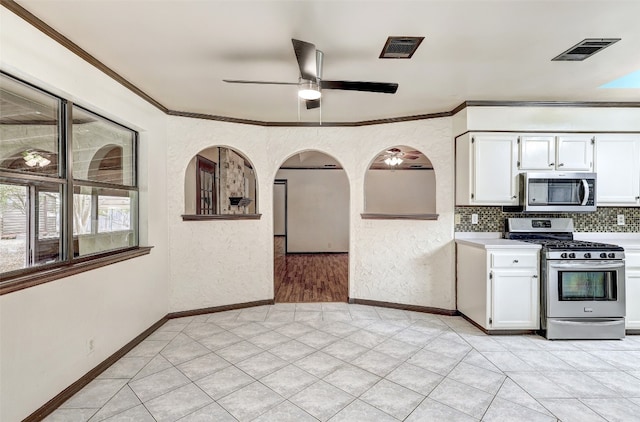 kitchen with appliances with stainless steel finishes, decorative backsplash, white cabinetry, and ceiling fan