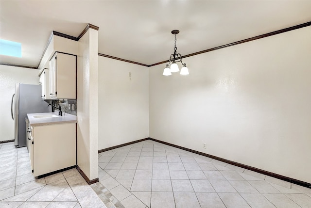 unfurnished dining area featuring light tile patterned floors, ornamental molding, sink, and a chandelier