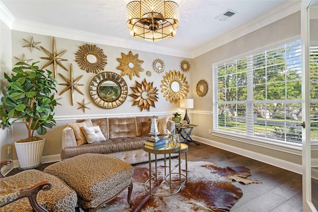 living room featuring hardwood / wood-style flooring, crown molding, and an inviting chandelier