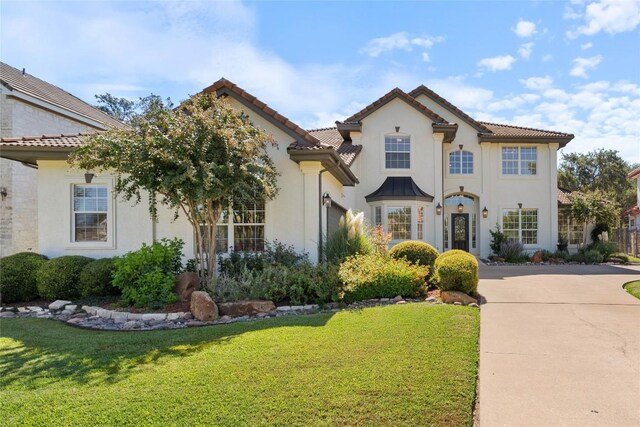 mediterranean / spanish-style house featuring a front yard