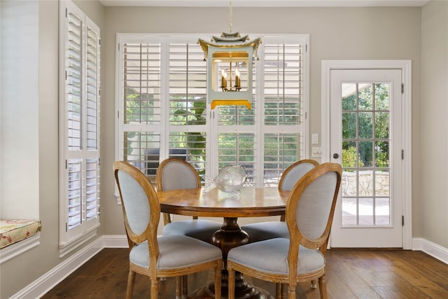 dining area featuring a chandelier, dark hardwood / wood-style floors, and a healthy amount of sunlight