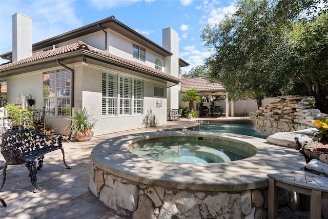 back of house featuring a gazebo, a pool with hot tub, and a patio