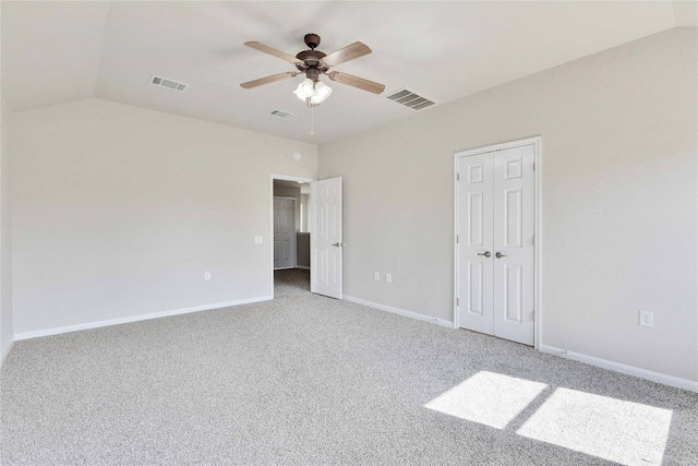 unfurnished bedroom featuring carpet floors, vaulted ceiling, and ceiling fan