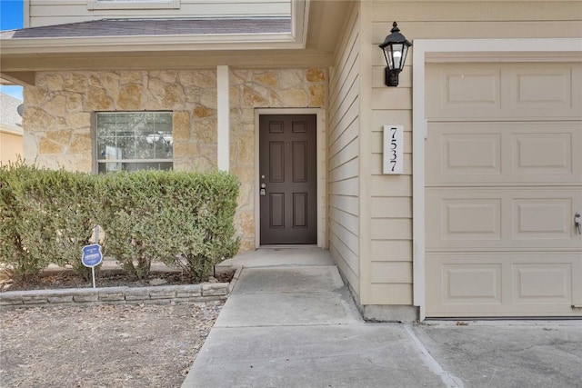 7537 S Glenn St, Austin, TX 78744 - view of exterior entry with stone siding, a garage, and roof with shingles