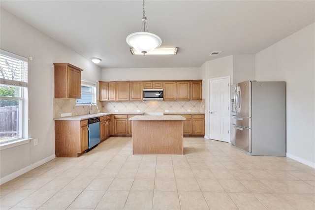 kitchen featuring a kitchen island, stainless steel appliances, a healthy amount of sunlight, and tasteful backsplash