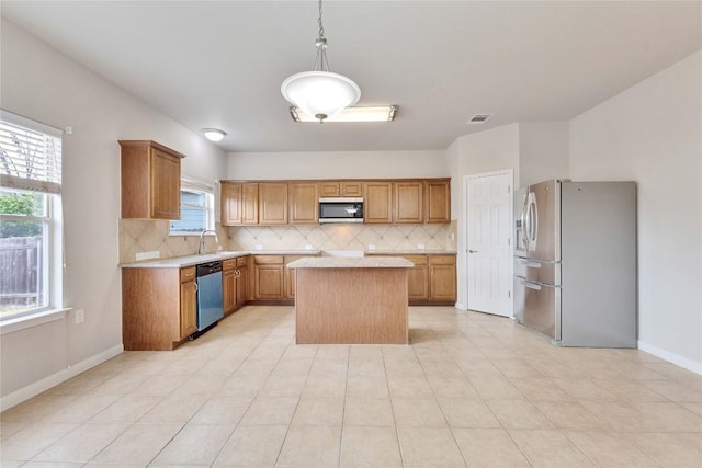 7537 S Glenn St, Austin, TX 78744 - kitchen with appliances with stainless steel finishes, light countertops, a kitchen island, a sink, and decorative backsplash