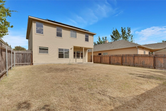 rear view of property featuring a patio and a yard