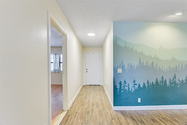 corridor featuring a textured ceiling and hardwood / wood-style flooring