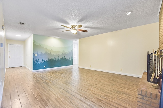 unfurnished living room with light hardwood / wood-style floors, a textured ceiling, and ceiling fan