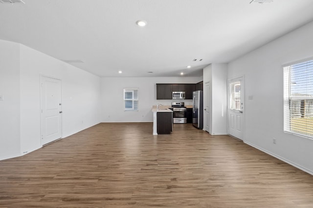 unfurnished living room with sink and wood-type flooring