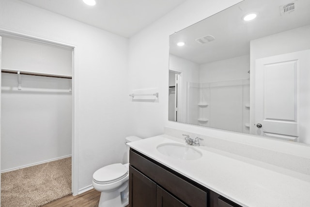 bathroom with vanity, toilet, and hardwood / wood-style flooring