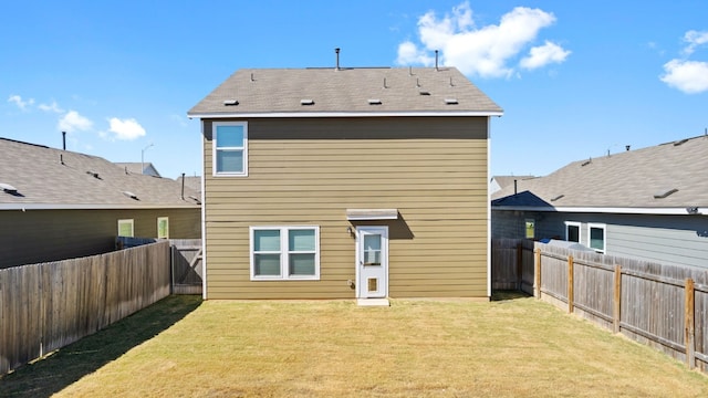 rear view of house featuring a yard