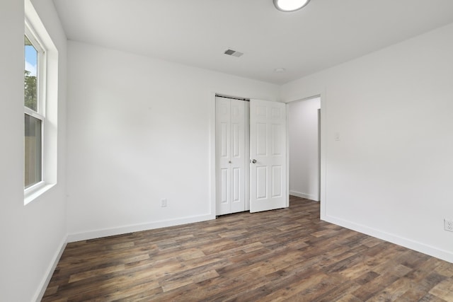 unfurnished bedroom with dark hardwood / wood-style flooring