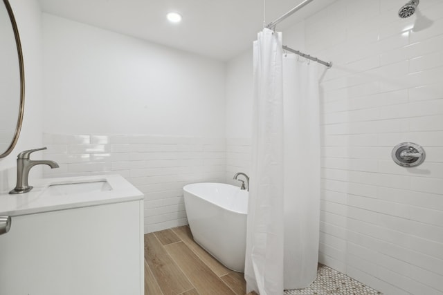 bathroom with vanity, tile walls, shower with separate bathtub, and hardwood / wood-style floors