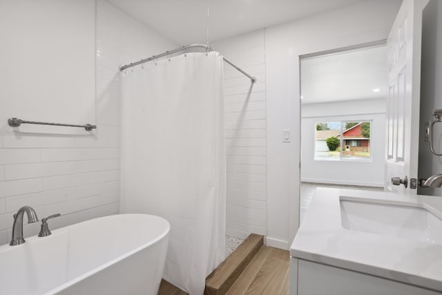 bathroom featuring vanity, wood-type flooring, and separate shower and tub