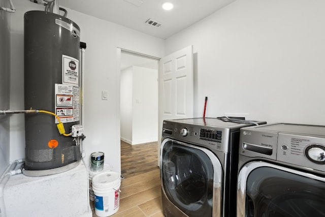 washroom featuring gas water heater, independent washer and dryer, and light wood-type flooring