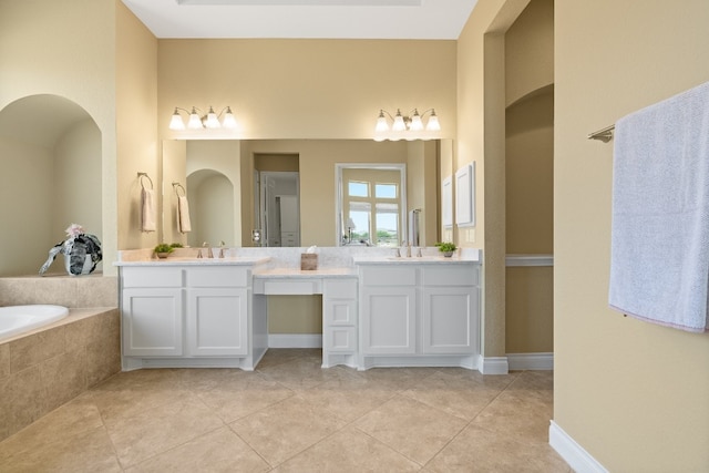 bathroom featuring vanity, a relaxing tiled tub, and tile patterned floors