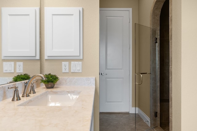 bathroom featuring a shower with door, vanity, and tile patterned floors