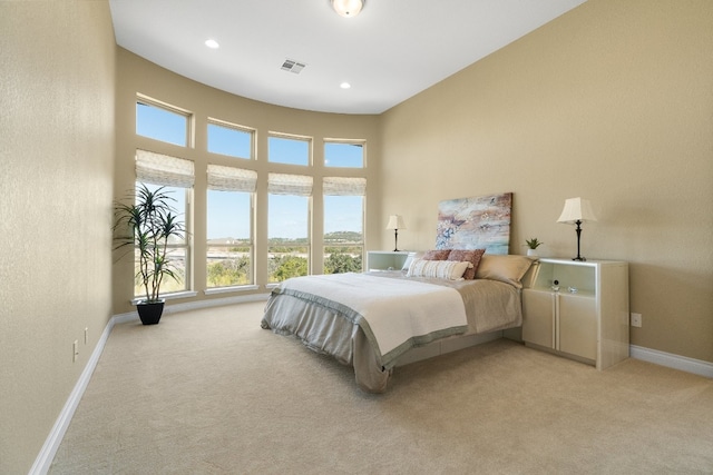 carpeted bedroom featuring a high ceiling