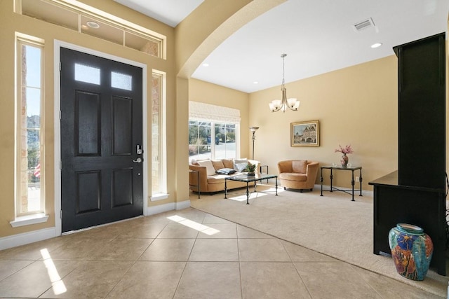 18201 Hewetson Cv, Austin, TX 78738 - carpeted entrance foyer with baseboards, tile patterned floors, a chandelier, arched walkways, and recessed lighting