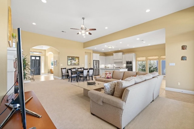 18201 Hewetson Cv, Austin, TX 78738 - living room featuring arched walkways, recessed lighting, a ceiling fan, baseboards, and light carpet