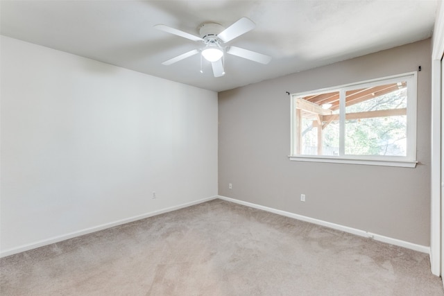 carpeted spare room with ceiling fan