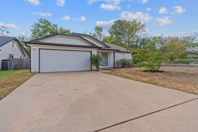 single story home featuring central AC unit and a garage