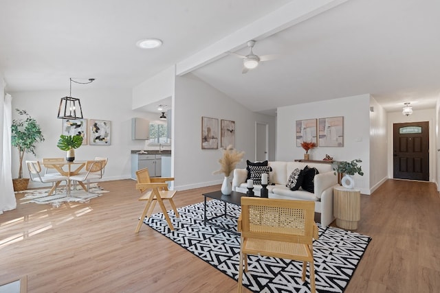 living room with ceiling fan, lofted ceiling with beams, and light wood-type flooring