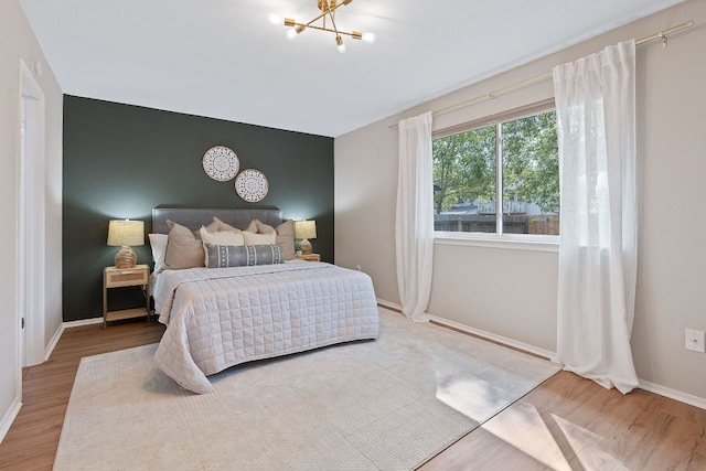 bedroom featuring hardwood / wood-style floors and an inviting chandelier