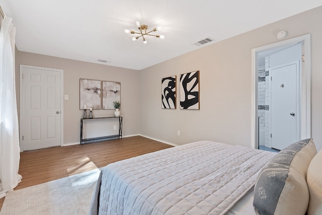 bedroom with hardwood / wood-style flooring, a spacious closet, and a notable chandelier