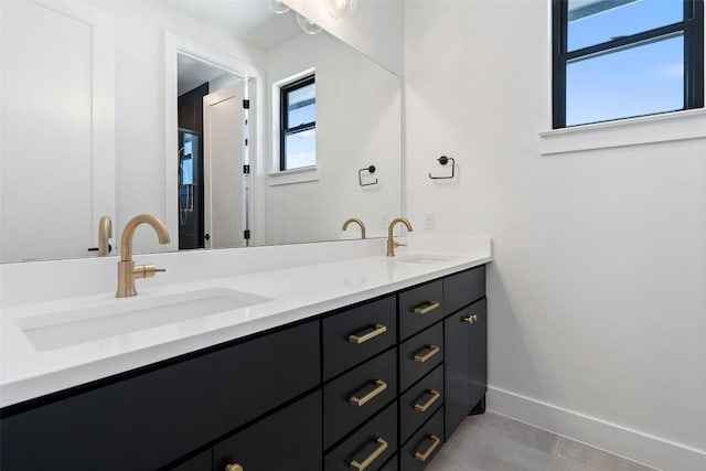 bathroom with a healthy amount of sunlight, double vanity, and a sink