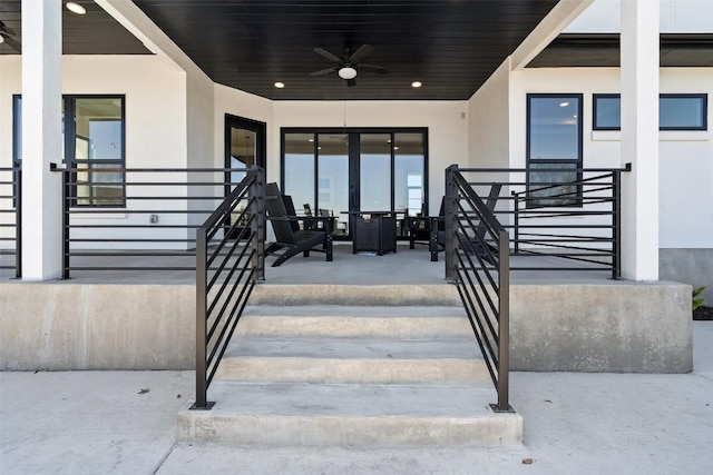 view of exterior entry featuring ceiling fan and stucco siding