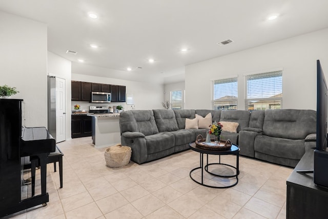 living area featuring light tile patterned floors, visible vents, and recessed lighting