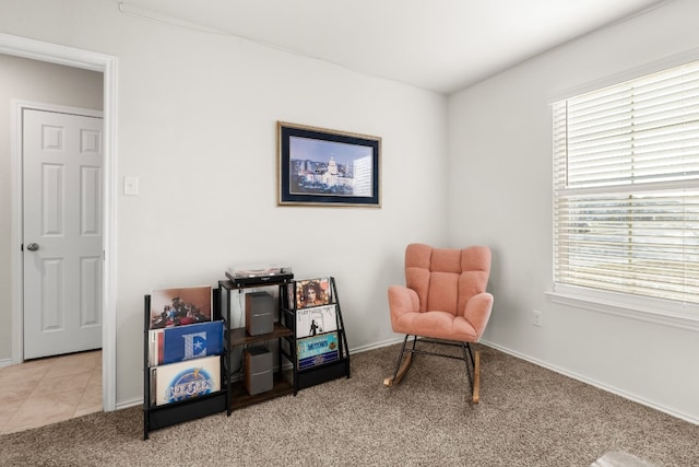 sitting room with carpet floors, baseboards, and tile patterned floors